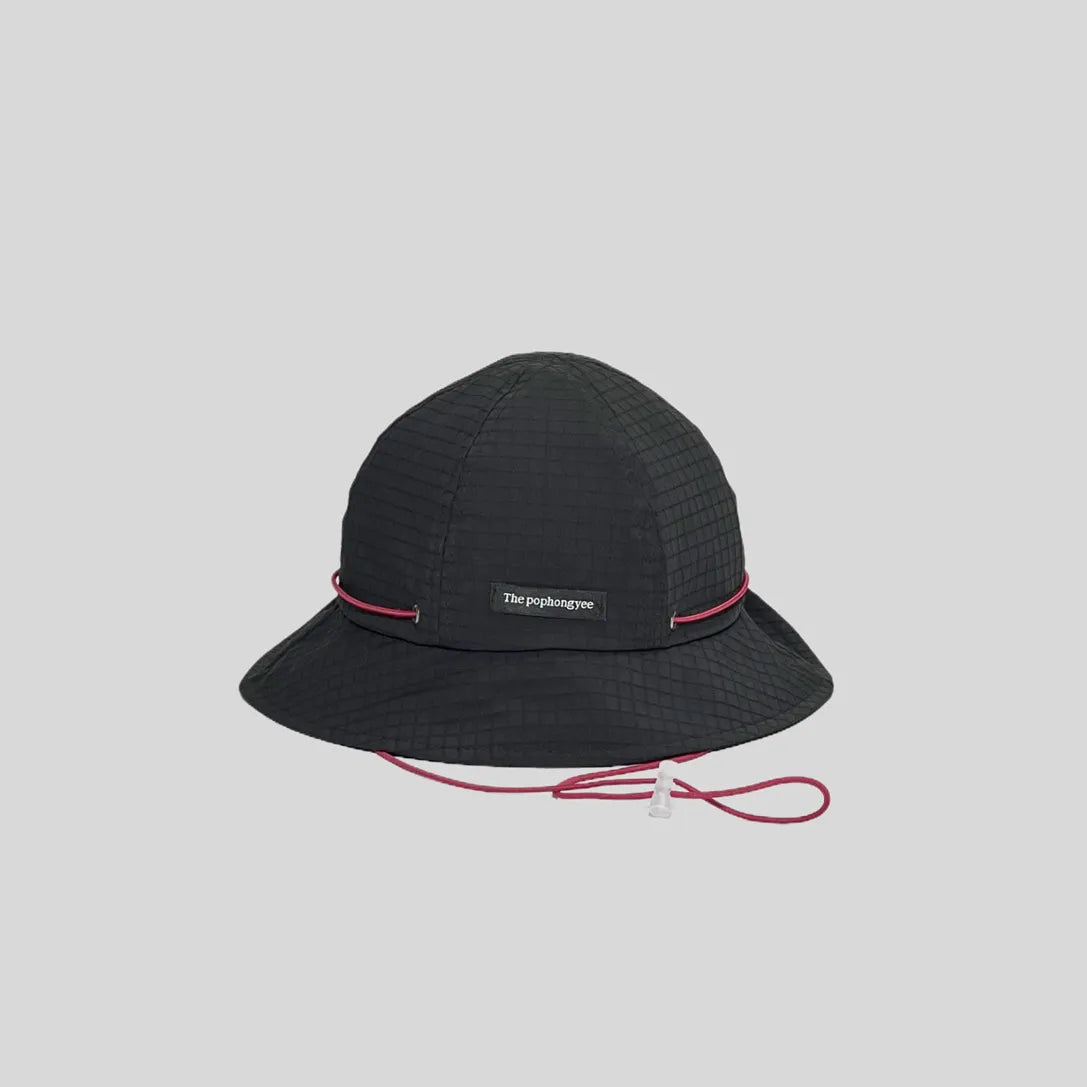 Quick-dry bucket hat in black with a pink cord, front view showing the logo tab, grid weave and wide brim