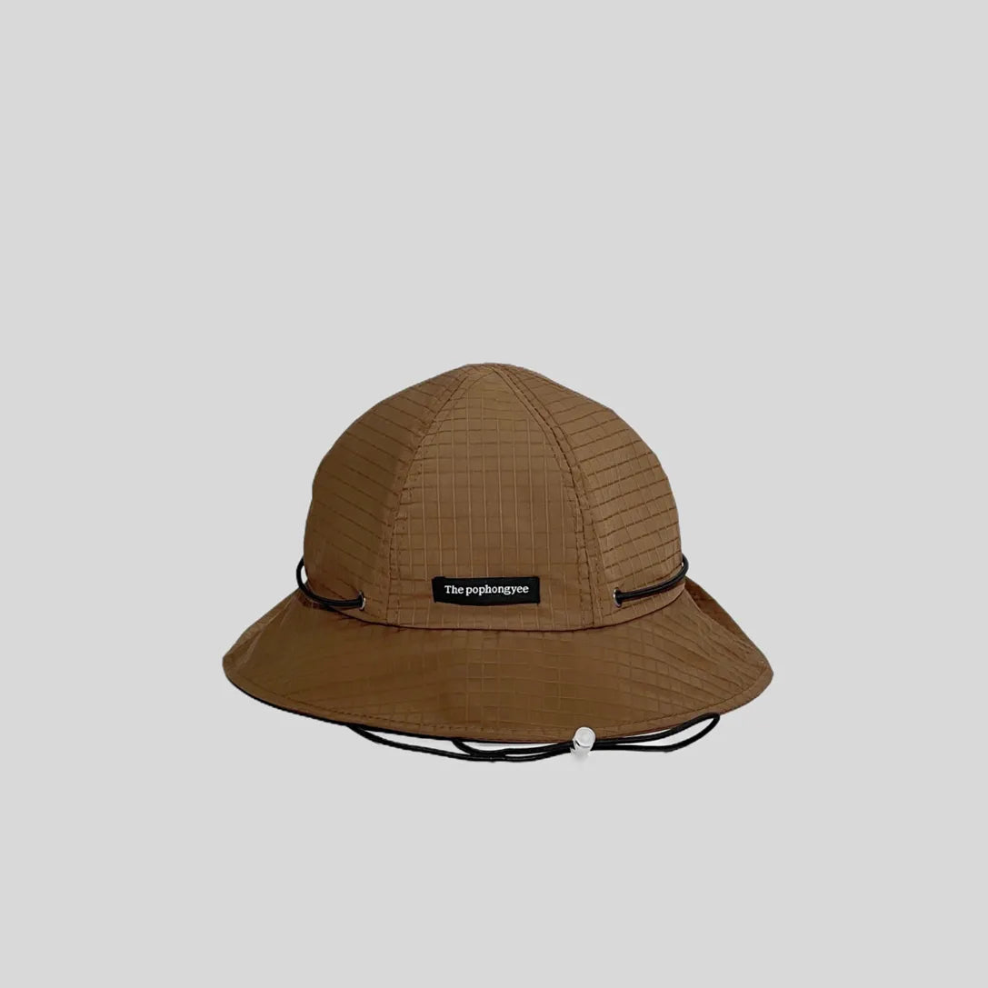 Quick-dry bucket hat in warm brown with a black cord, front view showing the logo tab, grid weave and wide brim