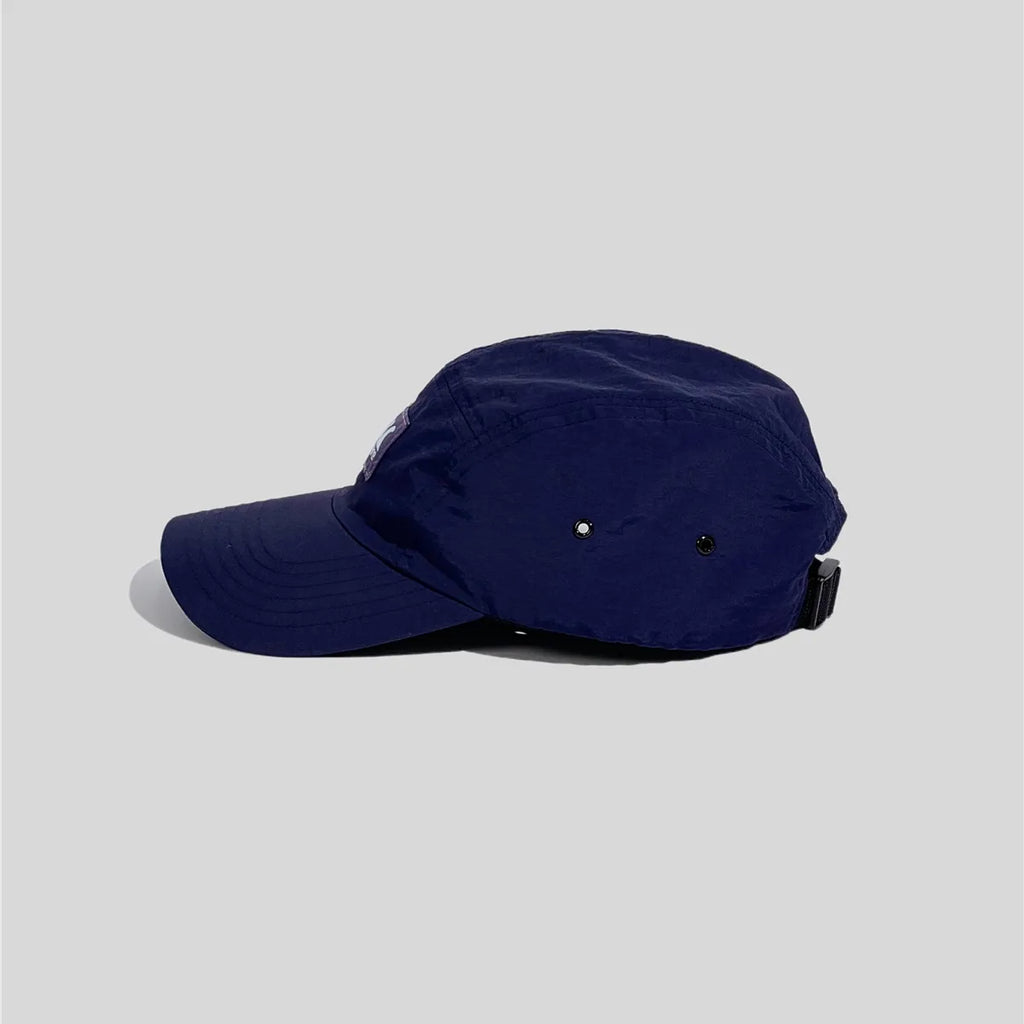 Quick-dry running cap in navy blue, shown from the side with twin metal eyelets and a black buckle strap