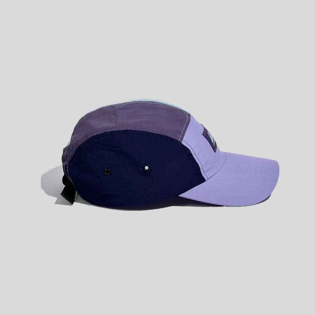 Quick-dry running cap in pastel colours, shown from the side with twin metal eyelets and a black buckle strap