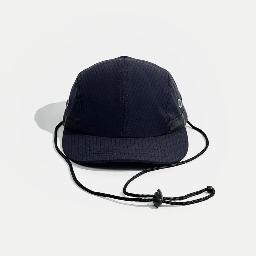 Quick-dry sports cap in navy blue, front view showing the low crown, curved peak and black chin cord