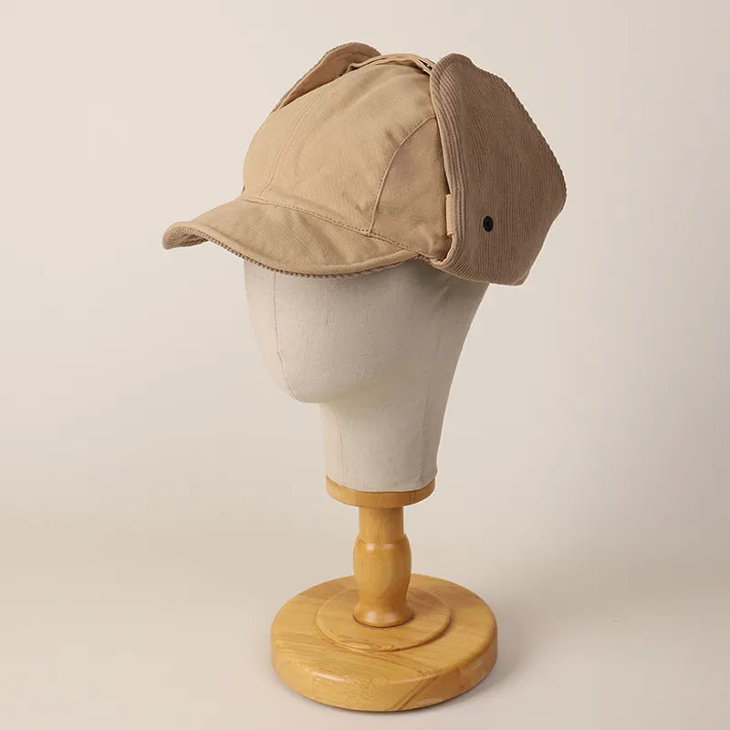 Beige reversible ear flap cap displayed with the textured side panels folded up around the crown.