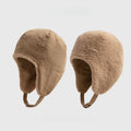 Beige reversible trapper hat shown with corduroy and teddy fleece sides, ear flaps and press-stud straps.