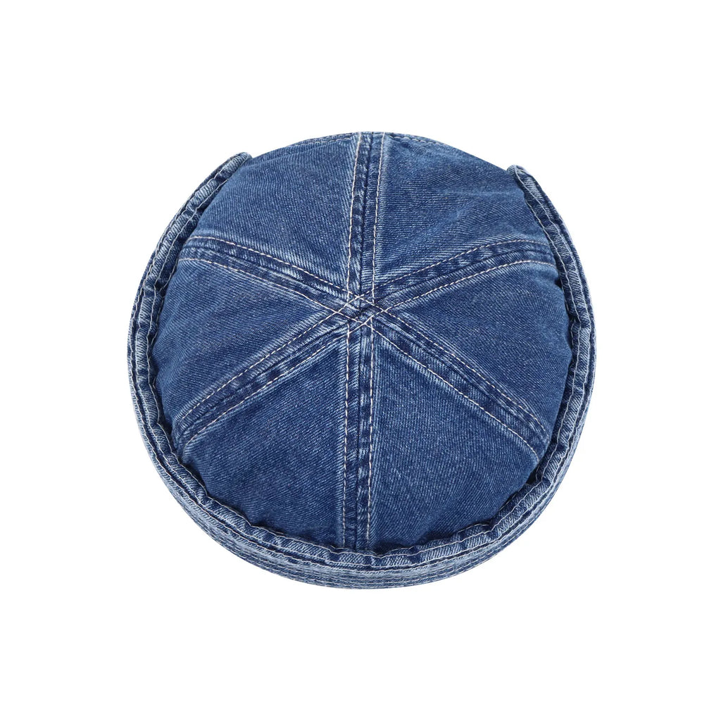 Six-panel denim hat in washed indigo, overhead view highlighting radial seams and the neatly stitched turn-up band