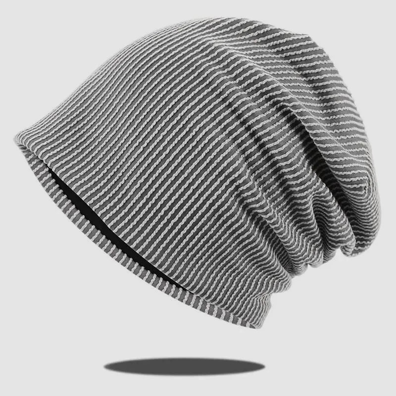 Light grey striped slouch beanie with fine contrast ribs, dark inner edge and relaxed back folds.