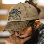 Man wearing a vintage cotton dad hat with a fish embroidery design and olive corduroy brim