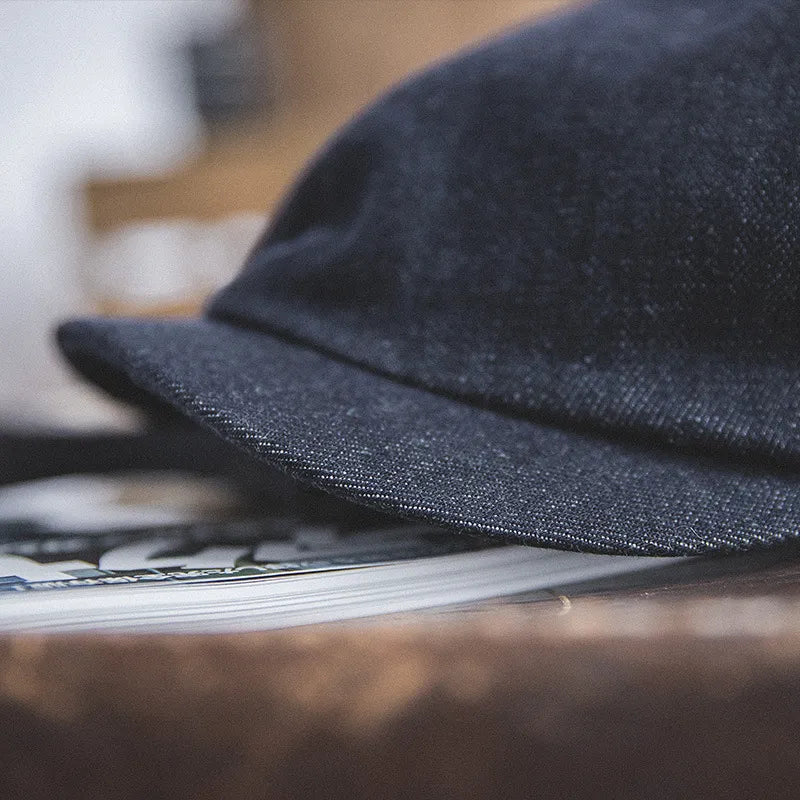 Vintage denim flat cap featuring structured panel seams and classic construction