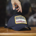 Man wearing a navy cotton baseball cap with an Adventure embroidered patch