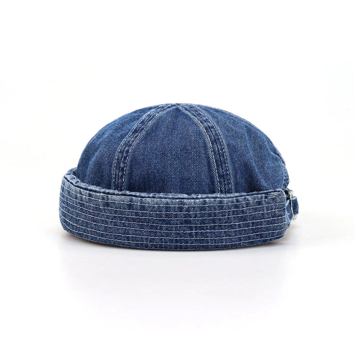 Brimless denim cap in washed indigo blue, side angle showing a rounded crown, rolled edge and pale topstitching