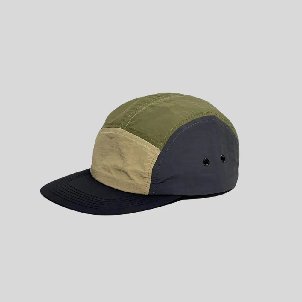 Waterproof 5-panel cap in olive, sand and charcoal, side view with colour-block panels, twin eyelets and black peak