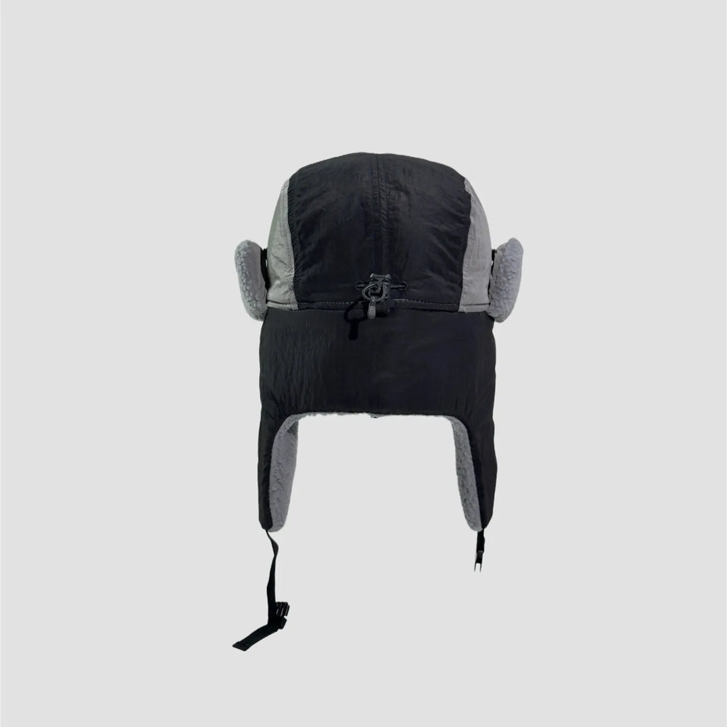 Black and grey nylon trapper hat rear view showing full neck flap coverage, soft lining edges and chin straps.