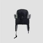 Black and grey nylon trapper hat rear view showing full neck flap coverage, soft lining edges and chin straps.