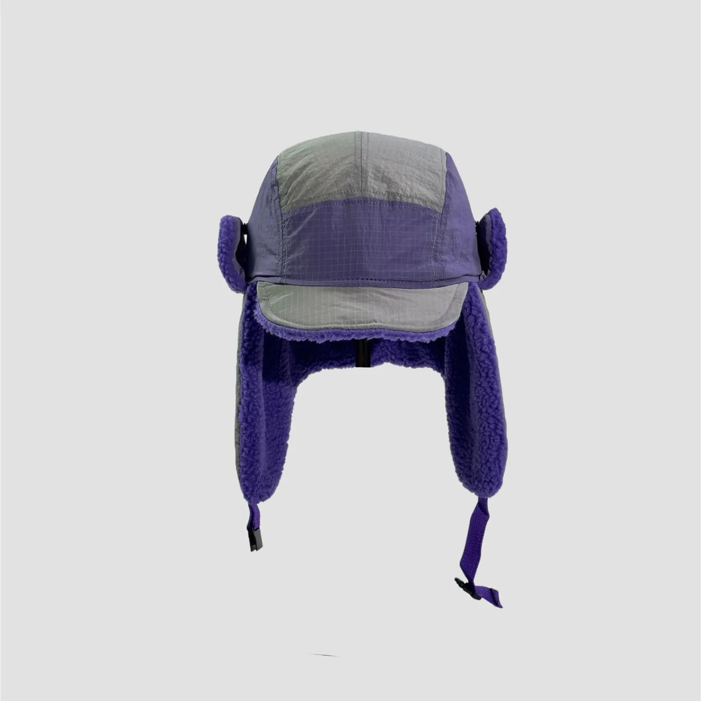 purple and grey windproof trapper hat front view with curved brim, long ear flaps and soft plush inner edges.
