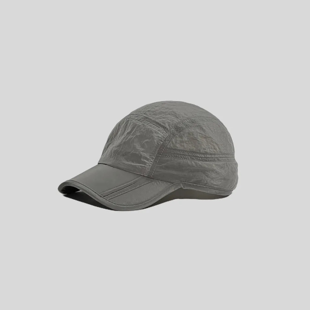 Waterproof running cap in light grey, angled side view showing the panelled crown, glossy texture and curved peak