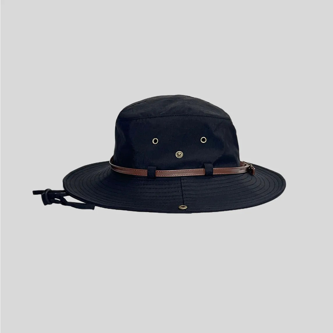 Wide brim safari hat in black, side profile with metal eyelets, brown trim band and multi-row brim stitching