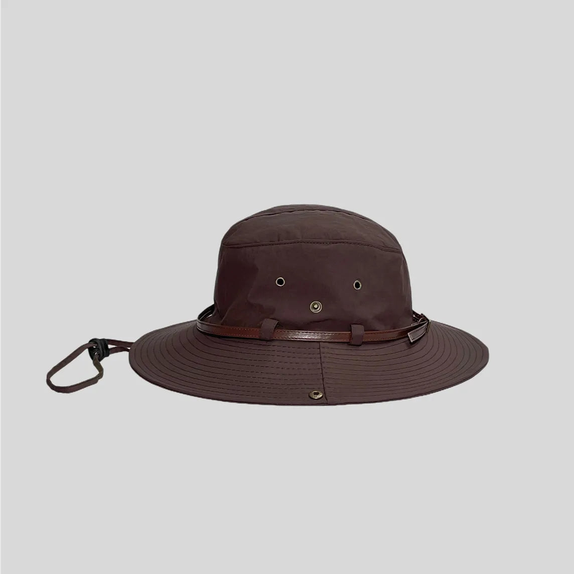 Wide brim safari hat in dark brown, side profile with metal eyelets, brown trim band and multi-row brim stitching