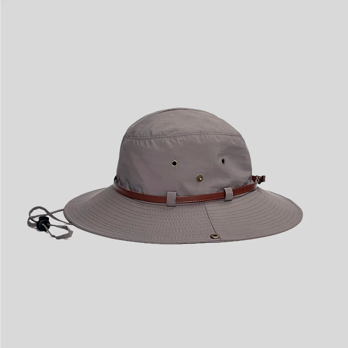 Wide brim safari hat in grey, side profile with metal eyelets, brown trim band and multi-row brim stitching