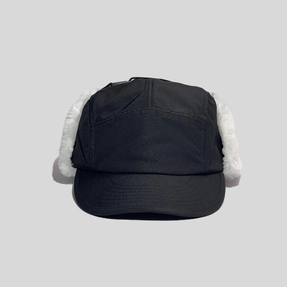 Winter baseball cap with ear flaps in black, front view with a panelled crown, curved peak and white plush trim
