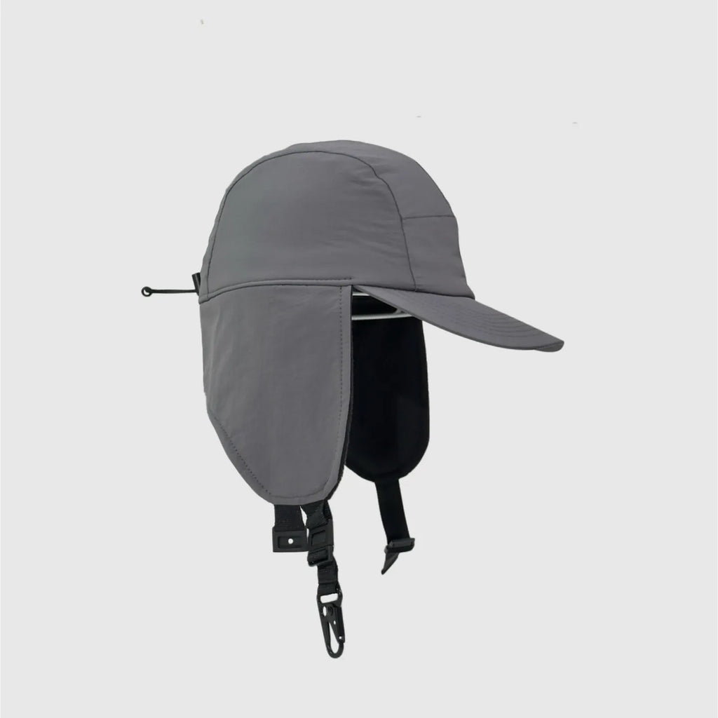 Grey winter ear cover cap side view with extended flap, rear toggle cord and curved peak.