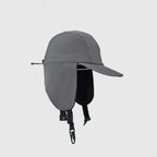 Grey winter ear cover cap side view with extended flap, rear toggle cord and curved peak.