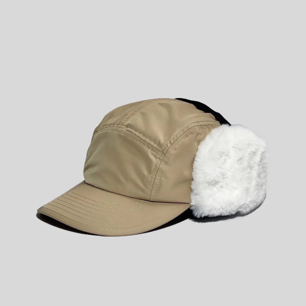 Winter trapper cap in khaki, angled to show smooth polyester panels, a stitched peak and full white plush ear coverage
